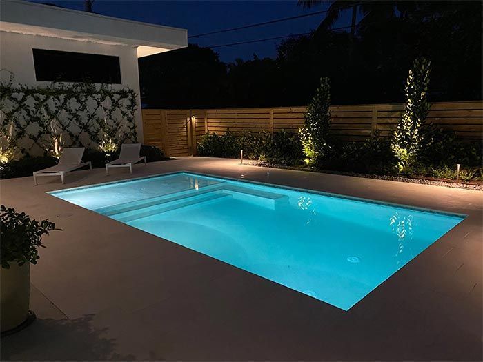 A large swimming pool is lit up at night