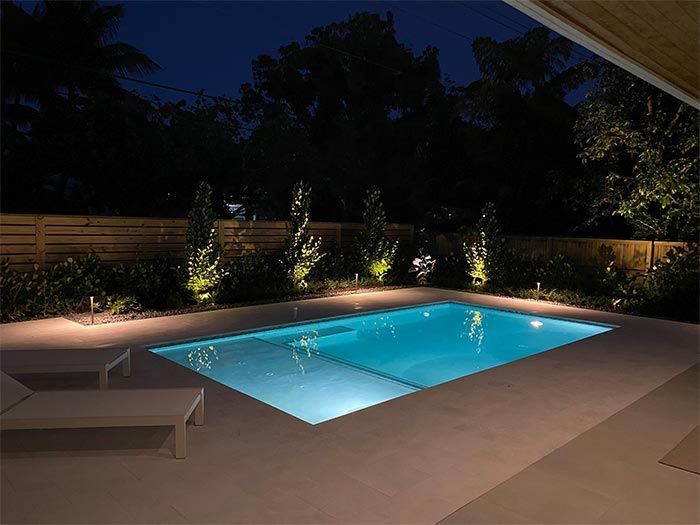 A large swimming pool is lit up at night