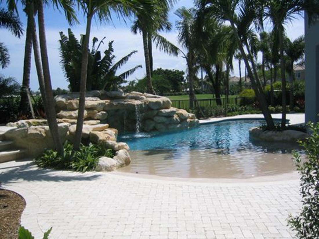 A large swimming pool with a waterfall in the middle