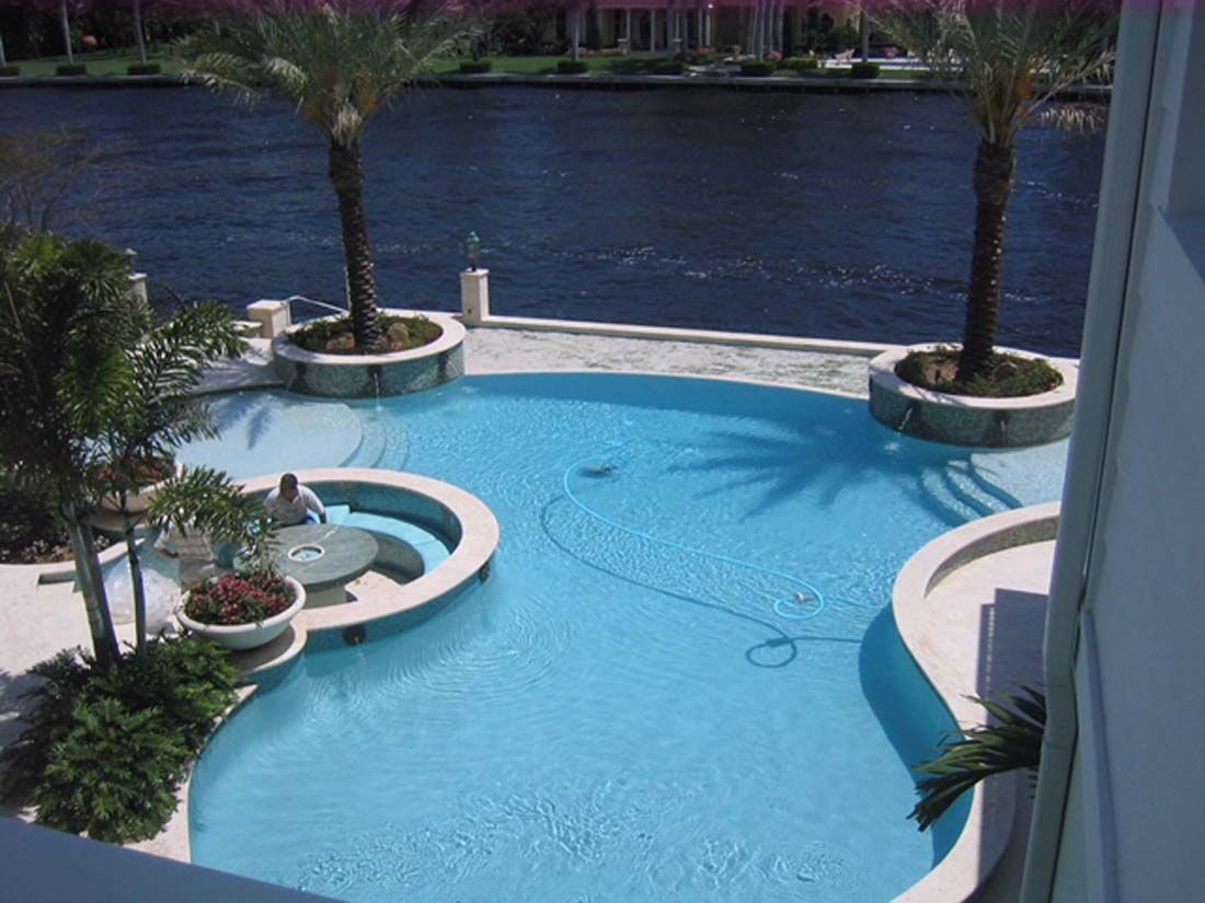 An aerial view of a large swimming pool surrounded by palm trees