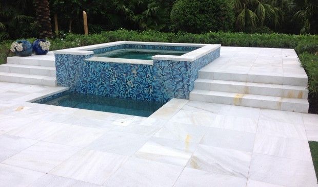 There is a swimming pool with a hot tub in the middle of it.