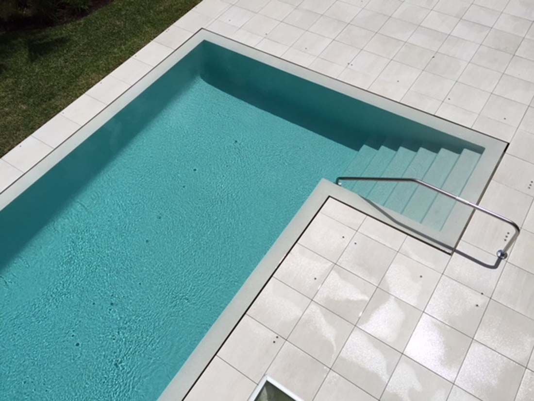 A large swimming pool with stairs leading to it