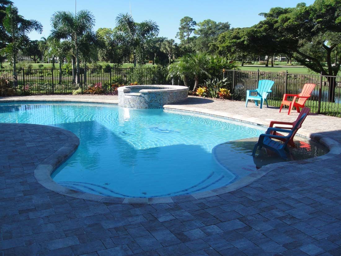 A large swimming pool surrounded by chairs and trees