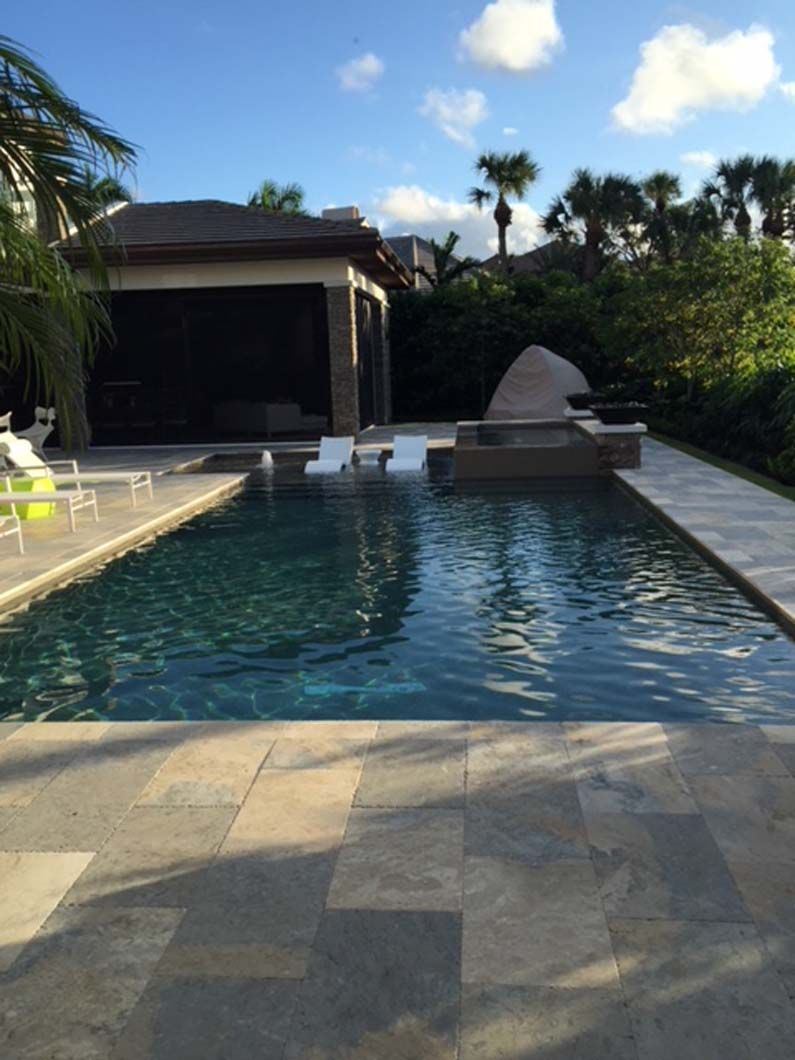 A large swimming pool with a house in the background