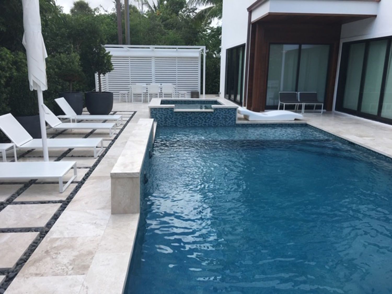 A large swimming pool surrounded by lounge chairs and umbrellas