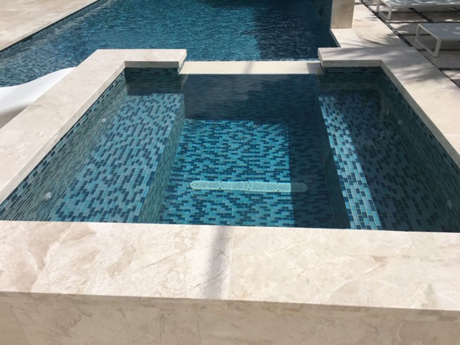 A large swimming pool with blue tiles and a white border