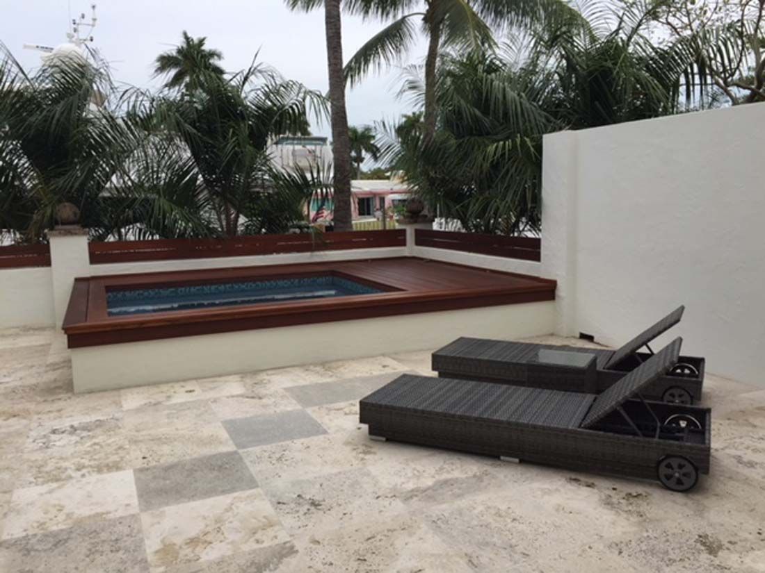 A swimming pool with two lounge chairs in front of it