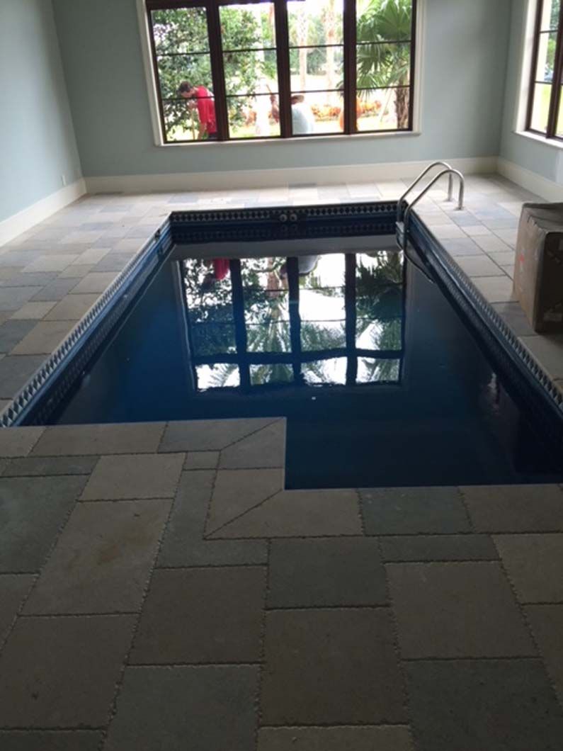 A large indoor swimming pool with a window in the background