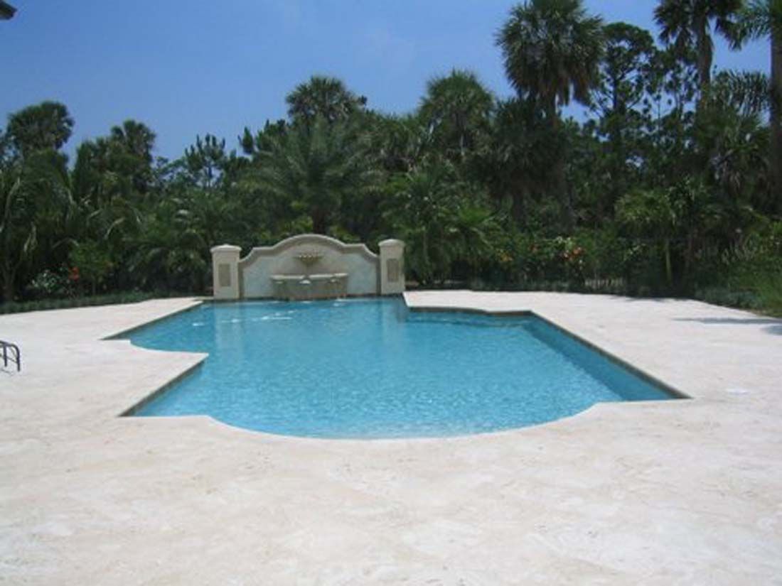 A large swimming pool surrounded by palm trees on a sunny day