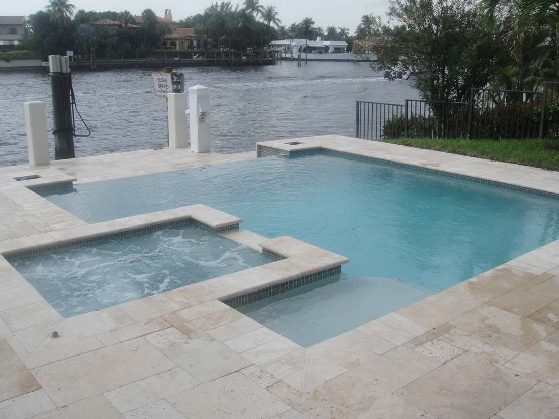A large swimming pool with a hot tub next to it