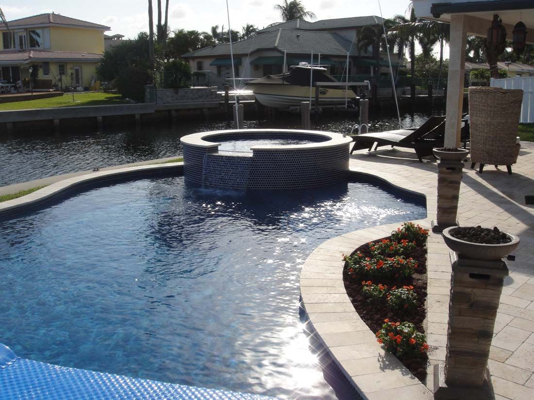 A large swimming pool with a hot tub in the middle