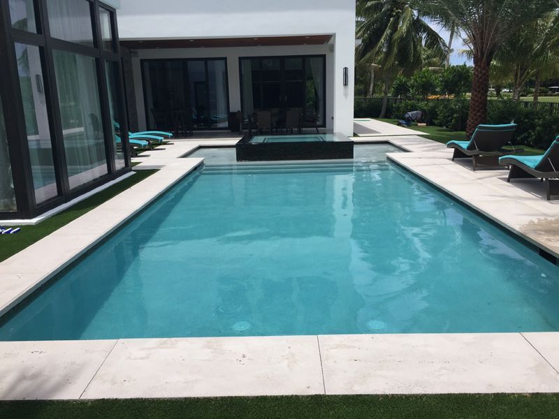 A large swimming pool in front of a house