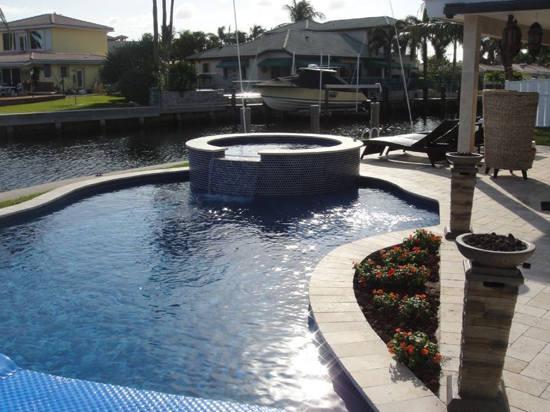 A large swimming pool with a hot tub in the middle