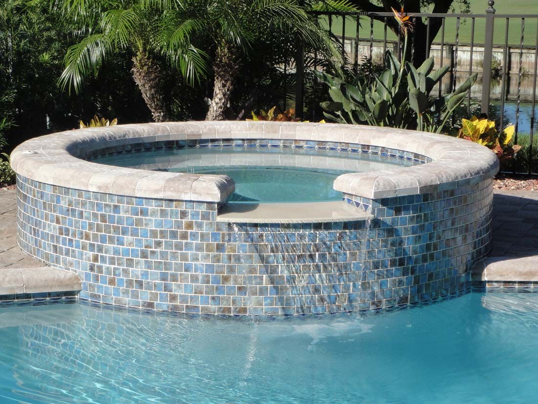 There is a hot tub in the middle of a swimming pool.