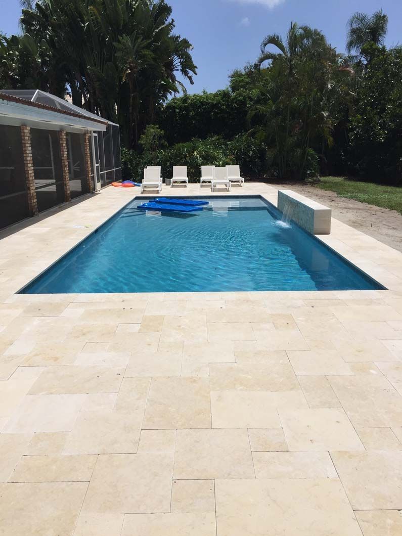 A large swimming pool surrounded by chairs and trees