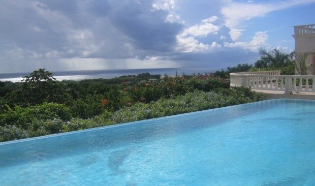 An infinity pool with a view of the ocean on a cloudy day