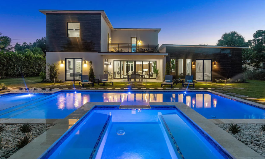 A large house with a large swimming pool in front of it.