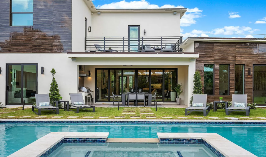 A large house with a swimming pool in front of it.