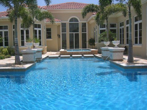 A large house with a swimming pool in front of it