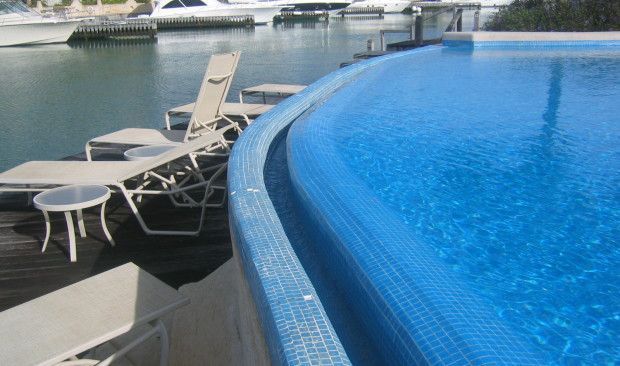 A large swimming pool with a boat in the background