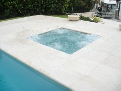 There is a hot tub in the middle of the pool.