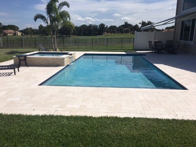 There is a large swimming pool in the backyard of a house.