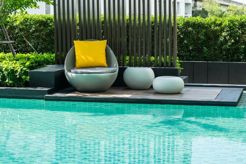 couch on side pool with yellow pillow