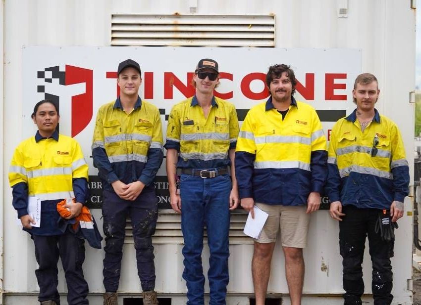 Five Construction Workers in Yellow and Blue Safety Vests Pose — Tincone Pty Ltd in Paget, QLD