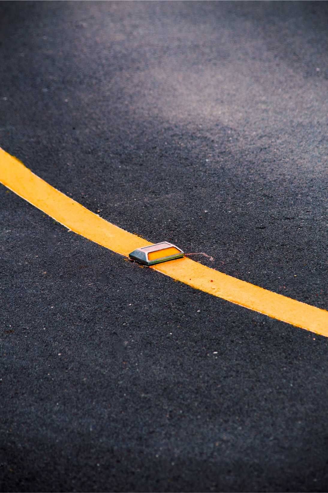 Yellow Road Line With a Reflective Marker on Dark Asphalt — Tincone Pty Ltd in Paget, QLD