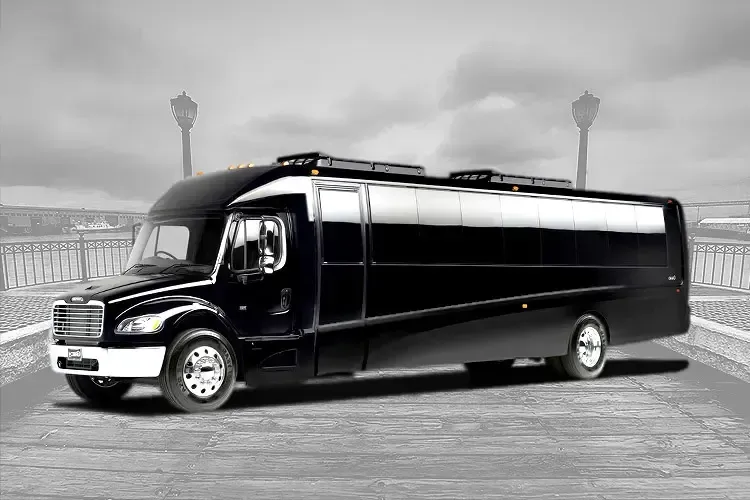 A black and white photo of a large bus parked on the side of the road.