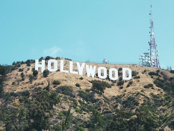 Hollywood sign on a hillside under a blue sky with a communications tower.