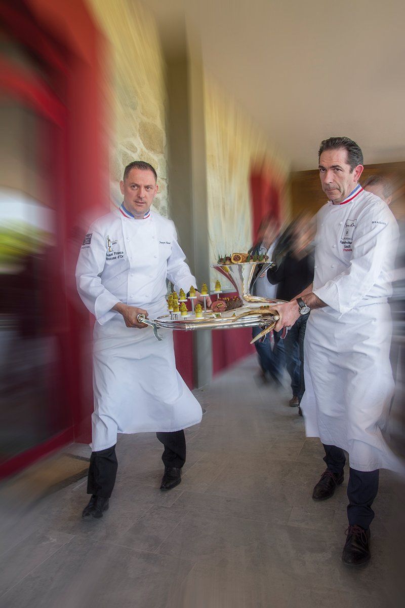 Le président du Team France et de l'académie culinaire apportent le plateau du plat de viande