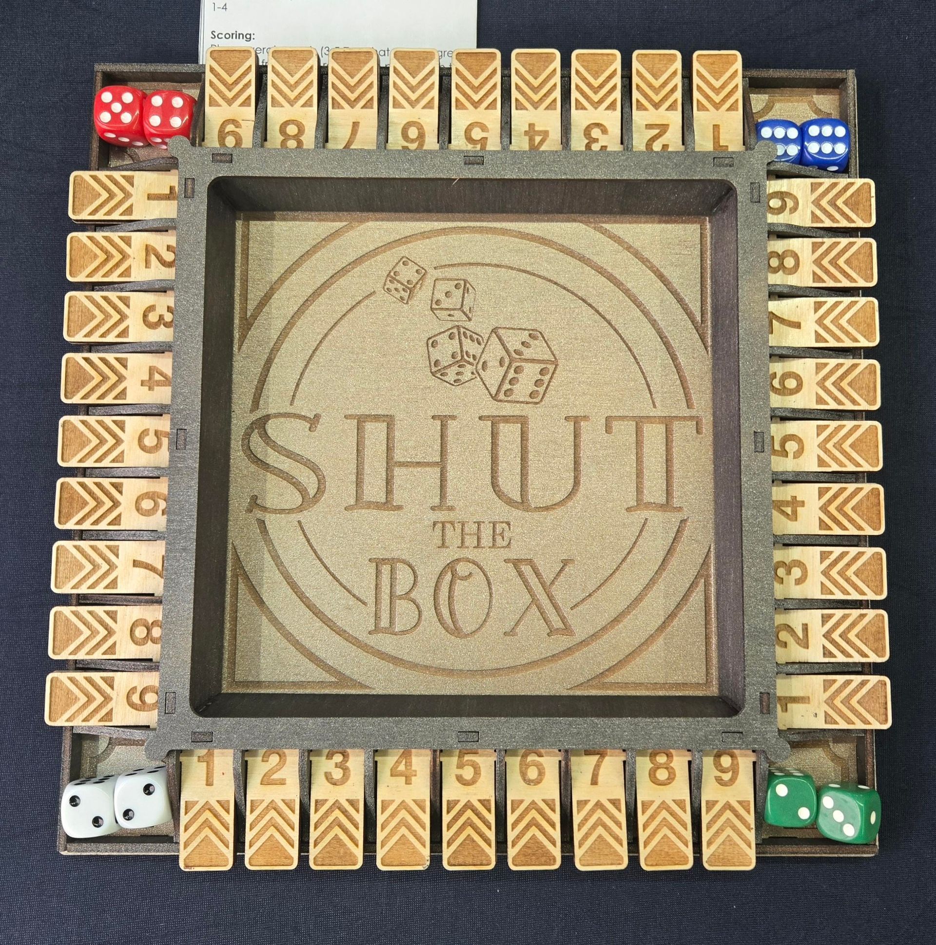 Shut the Box game board with dice, numbered tiles, and a central logo.