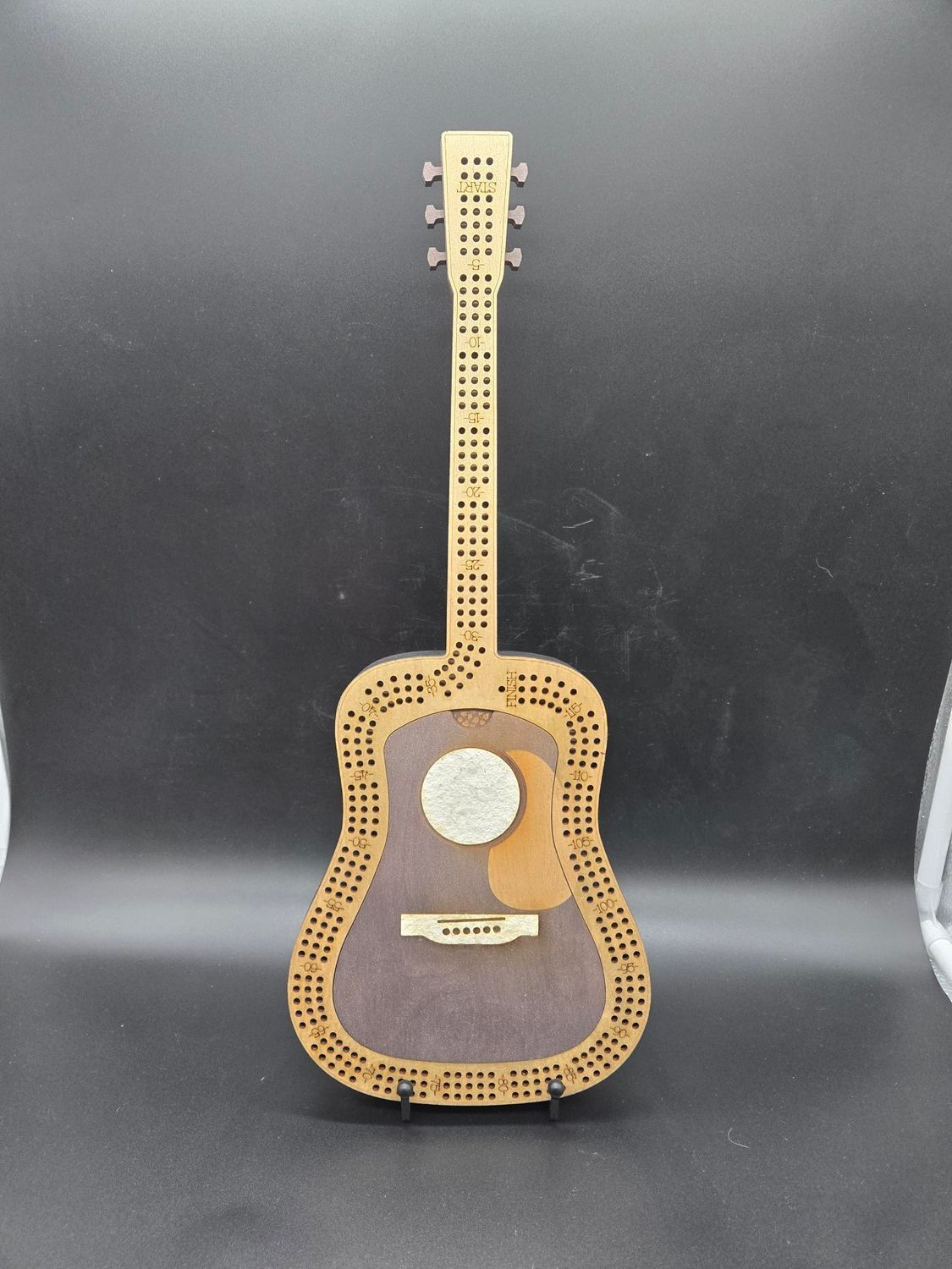 Wooden decorative guitar with a detailed design.
