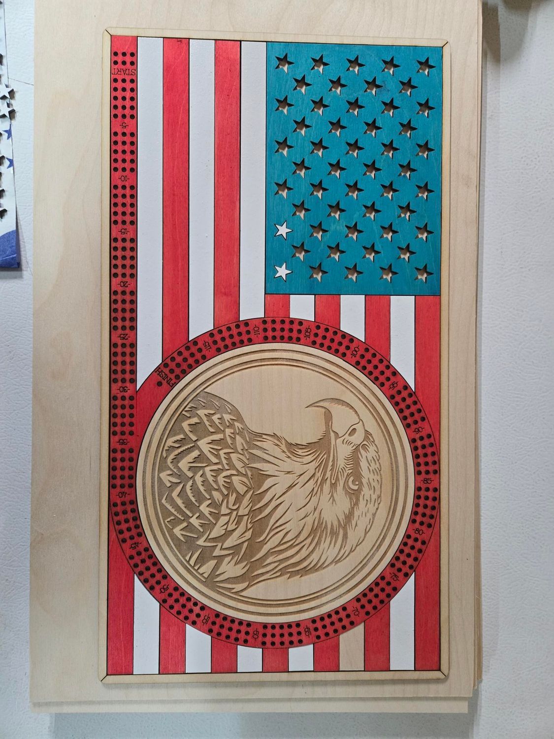 Wooden art piece of American flag with eagle, red, white, blue.