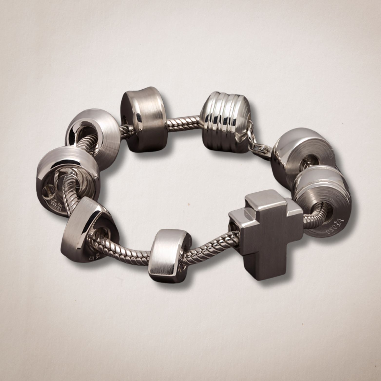 Een zilveren armband met een kruis erop