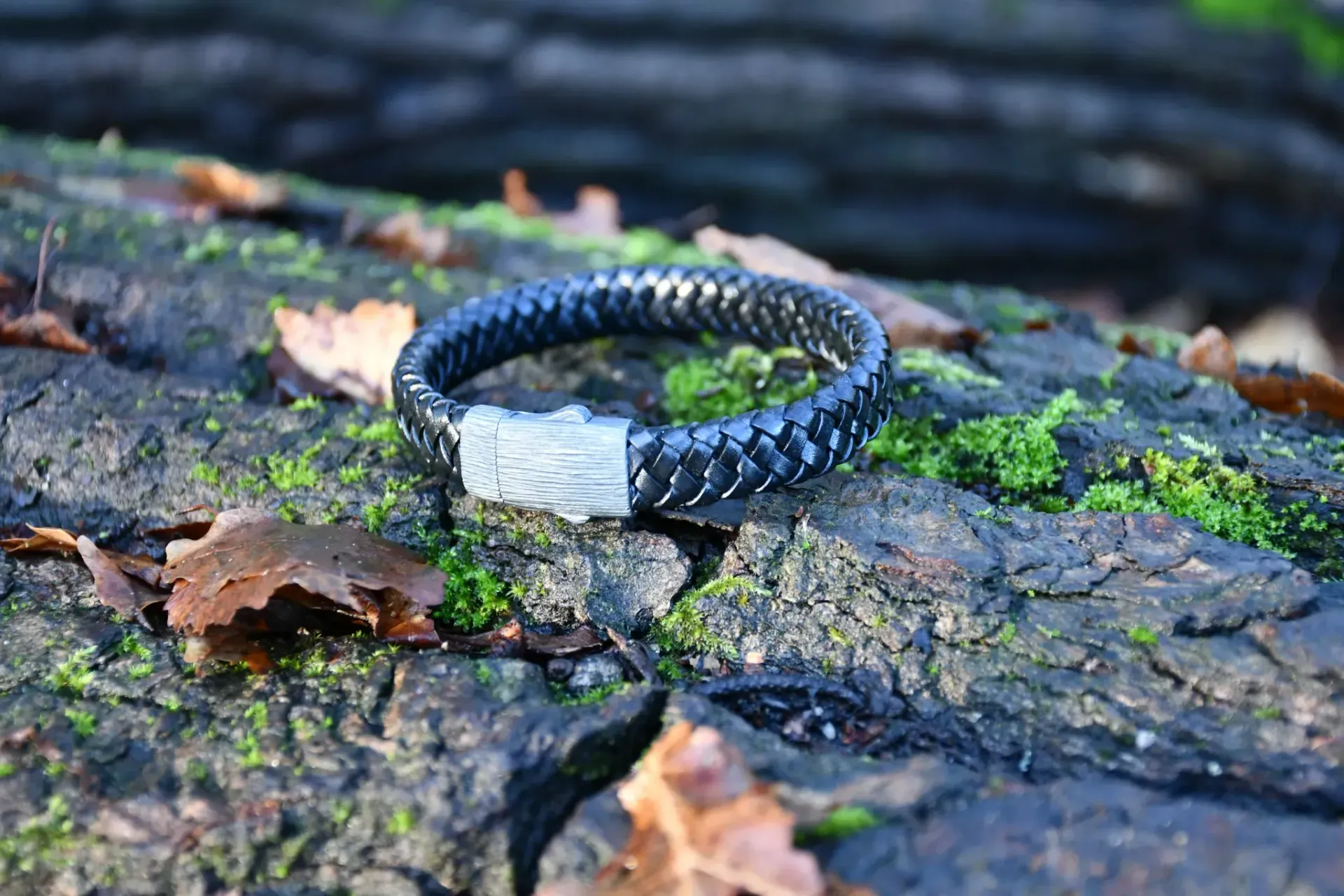 Een zwarte gevlochten leren armband met een zilveren sluiting