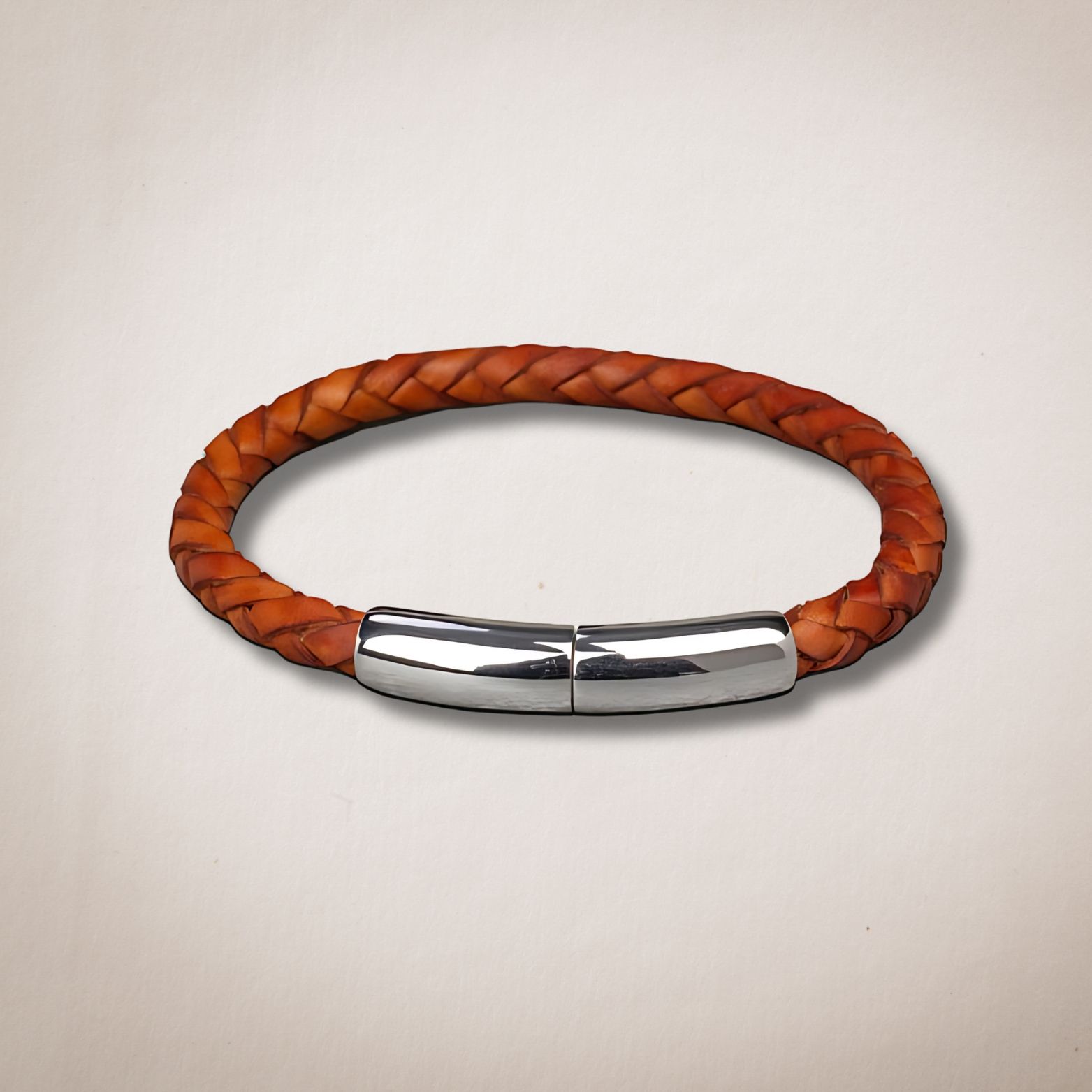 Een bruine gevlochten leren armband met een zilveren sluiting