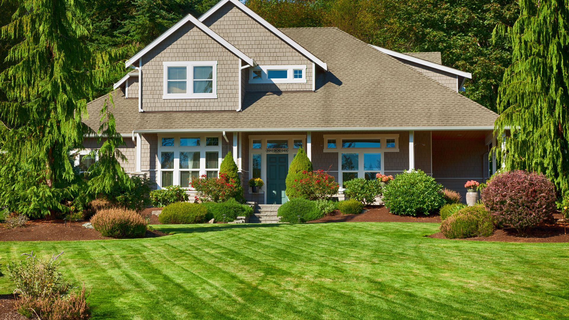 A large house with a lush green lawn in front of it.