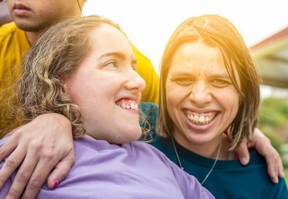 A group of people are standing next to each other and smiling — Eleos Support Services In Lavington, NSW