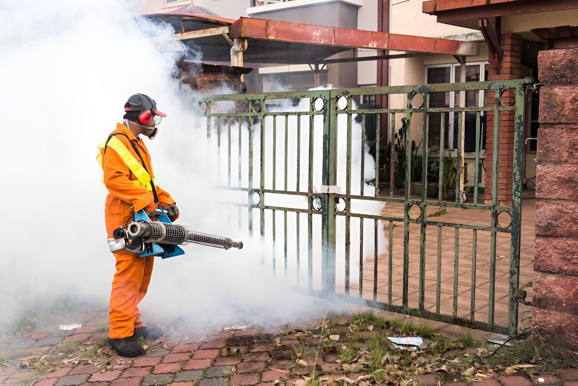 Man is Spraying a Fence With a Machine — Shark Pest Control in Maroochydore, QLD