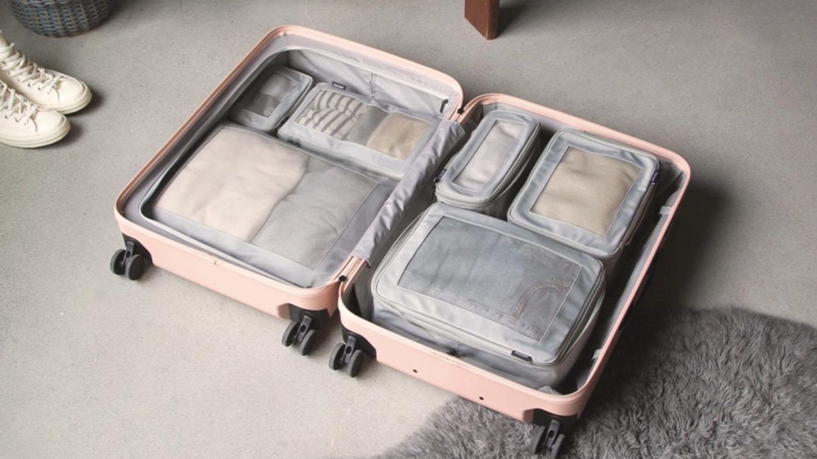 A pink suitcase with packing cubes being used