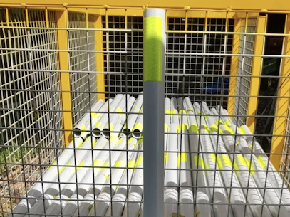 Yellow and gray reflective road markers stored in a yellow wire cage.