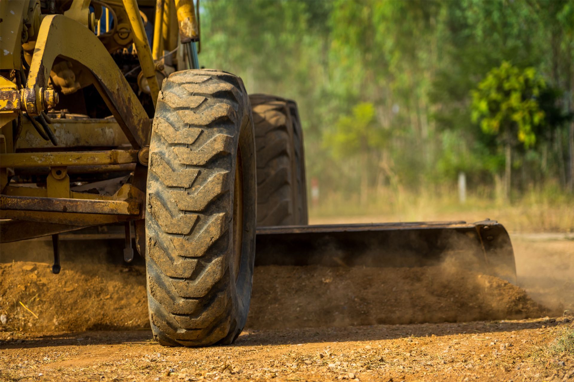 A bulldozer is moving dirt on a dirt road
