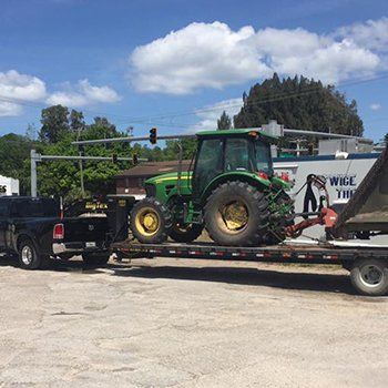 Moving Tractor On A Vehicle — Lakewood Ranch FL — Emerald Green of Bradenton Moving Tractor On A Vehicle — Lakewood Ranch FL — Emerald Green of Bradenton