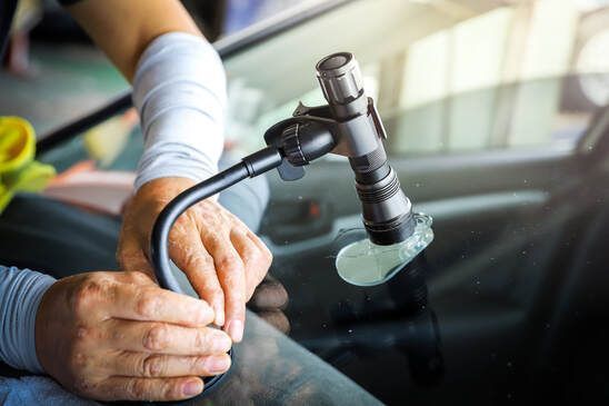 Close-up of professional auto glass repair service on a vehicle.