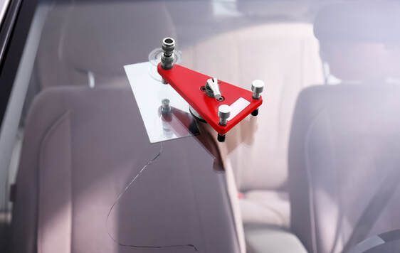 Professional windshield crack repair kit set up on a car.