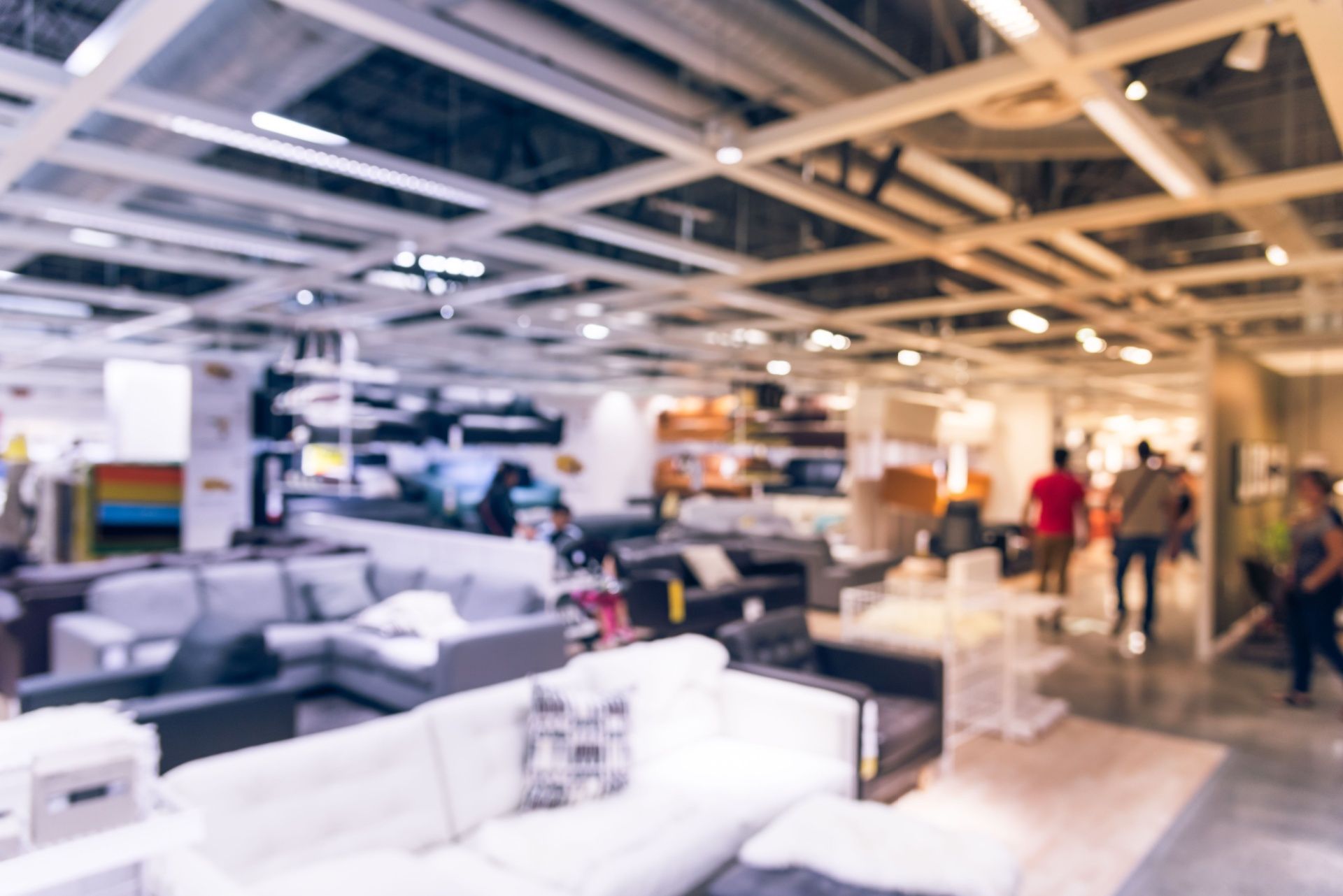 A blurry picture of people shopping in a furniture store.