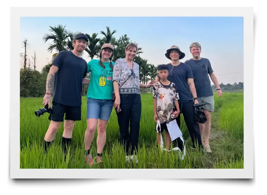 A group of people are posing for a picture in a field.