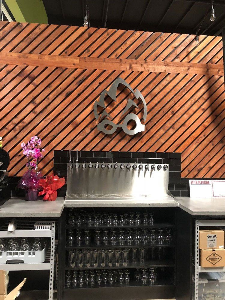 A restaurant with a wooden wall and a stainless steel bar